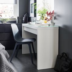 a bedroom with a desk, chair and window in the corner next to a bed