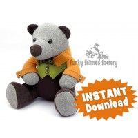 a teddy bear sitting on the ground with an orange tag around it's neck