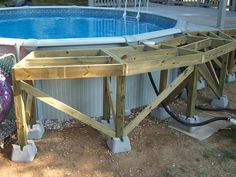 an above ground swimming pool being constructed with wooden beams and water hoses attached to it