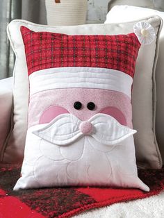 a santa clause pillow sitting on top of a couch