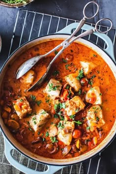 a large pot filled with stew on top of a metal rack next to other dishes