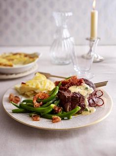 a white plate topped with meat and green beans