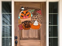 a wooden door decorated with an image of a pumpkin in a bucket and other items