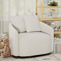 a white chair sitting in a living room next to a stuffed giraffe