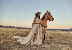 a woman in a dress is standing next to a horse