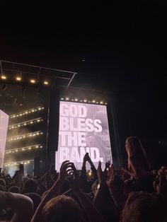 people are standing in front of a large screen with the words god bless the brand on it