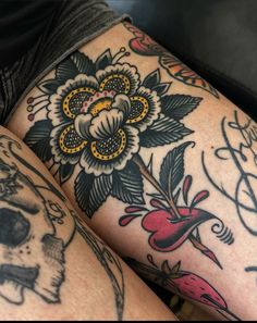 tattoos on the legs of two people with flowers and skulls tattooed on their leggings