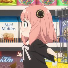 a girl in a store with pink hair is looking at the food on display behind her