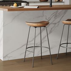 two stools in front of a marble counter top