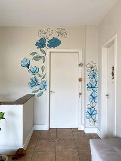 a room with some blue flowers painted on the wall