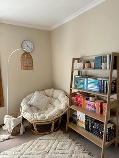 a living room with a book shelf, chair and bookshelf