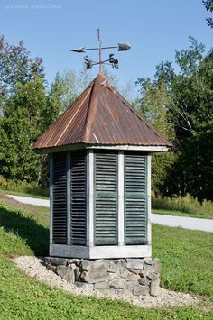 an old fashioned outhouse sits in the grass