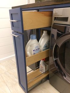 a washer and dryer in a kitchen next to each other with bottles of cleaner