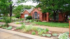 a brick house with landscaping in front of it