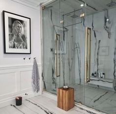 a bathroom with marble walls and flooring next to a walk - in shower stall