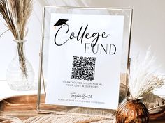 a college fund sign sitting on top of a table next to a vase with dried grass