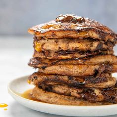 stack of pancakes covered in syrup on a white plate