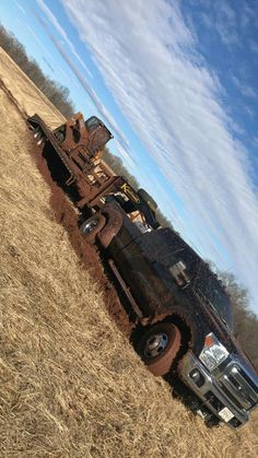 a large truck is parked in the middle of a field with no grass on it