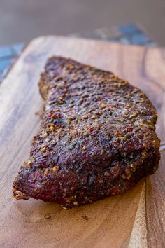 a piece of meat sitting on top of a wooden cutting board