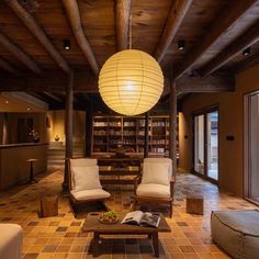 a living room filled with lots of furniture and a large lamp hanging from the ceiling