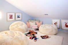 a bedroom with two bean bags on the floor and pictures on the wall above it