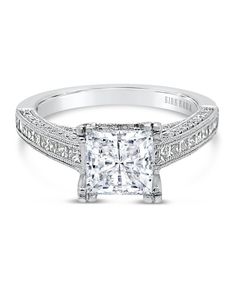 a princess cut diamond engagement ring with side stones on the shoulders and sides, set in white gold