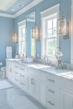 a large bathroom with two sinks, mirrors and lights on the wall above them is shown