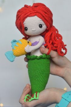 a crocheted mermaid doll holding a stuffed bird in it's hand,