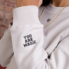 "A stylish, slogan sweatshirt that comes with an empowering slogan on the cuff. This magical sweatshirt is the perfect gift for that amazing person in your life - or yourself! Each sweatshirt is luxuriously soft, ethically made and approved by the fairwear foundation. With a cosy brush fleece lining, this design features a small embroidered star on the front. On the cuff, there is embroidery that reads \"You are magic\" - a small reminder for you throughout the day. Choose your sweatshirt colour Idee Cricut, Amazing Person, Slogan Sweatshirt, Cooler Look, Rock On, Embroidered Sweatshirt, Personalized Embroidered, Embroidered Sweatshirts