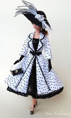 a doll is dressed in black and white polka dot dress with matching hat, purse and heels