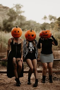 three women in halloween costumes with pumpkin heads