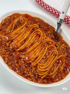 a white bowl filled with spaghetti on top of a table