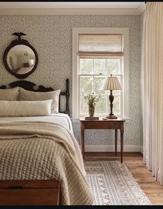 a bed sitting next to a window with a lamp on top of it in a bedroom