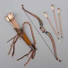 an assortment of different types of bow and arrow bows on a gray surface with two arrows pointing at each other