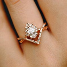 a woman's hand with a diamond ring on top of her finger and an engagement band