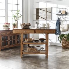 a wooden table sitting in the middle of a living room next to a potted plant