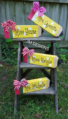 three wooden signs with bows on them sitting in the grass