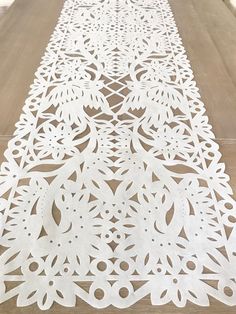 a long white table runner with intricate cut outs