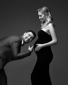 a man standing next to a woman in a black dress