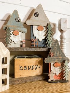 three wooden houses with happy written on the front and back, sitting next to each other