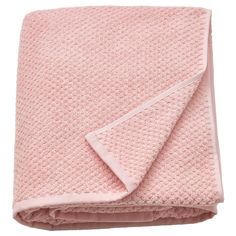 a pink blanket folded on top of a bed