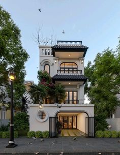 a large white house with lots of windows and balconies on the top floor