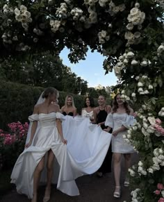 the brides are walking down the path with their dresses flowing in front of them