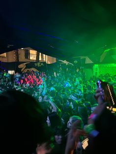 a crowd of people at a concert with their cell phones in the air and lights on