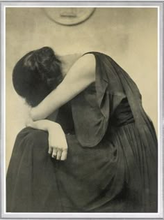 an old black and white photo of a woman hugging her head