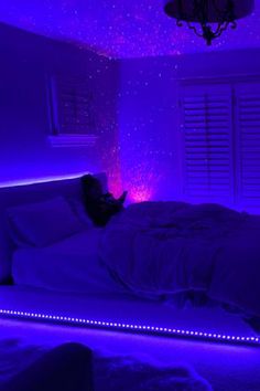 a bed in a room with purple lights on the walls