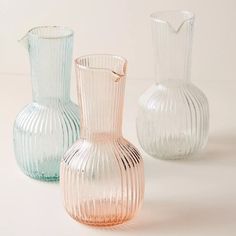 three glass vases sitting next to each other