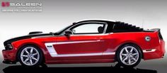 a red and black mustang parked in front of a white wall