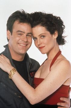 a man and woman hugging each other with one arm around the other's shoulder