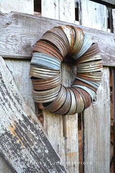 an old door with a metal wreath on the front and side of it that is made out of tin cans